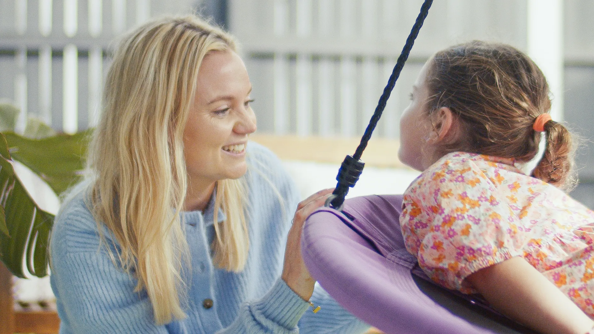 Hayley working with a child on the sensory swing in the Wild Springs therapy room
