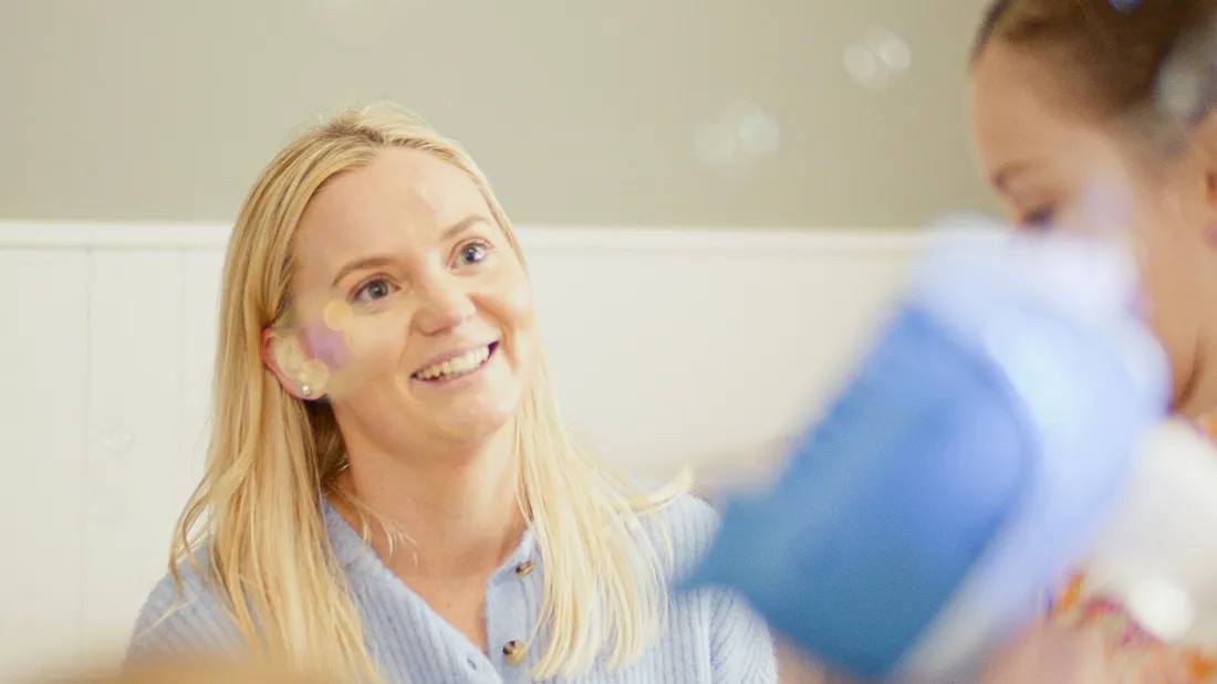 Hayley blowing bubbles with a young client in the therapy space